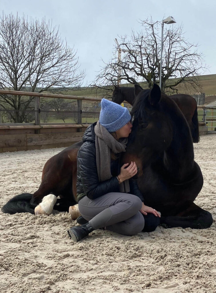 Pferd und Julia Gutmann sitzend auf Reitplatz